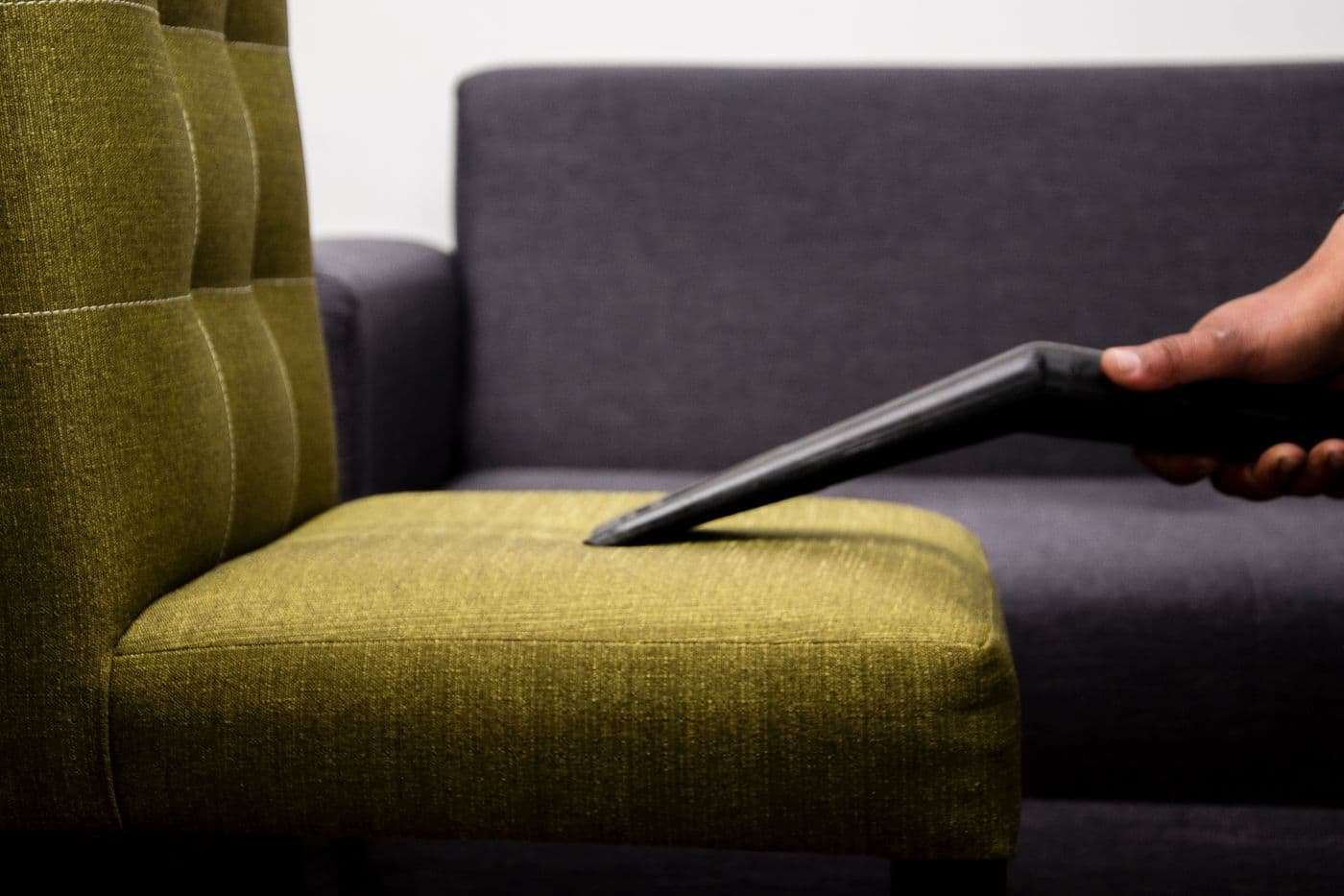 Aspiration de l'assise en tissu d'un canapé avec un suceur plat